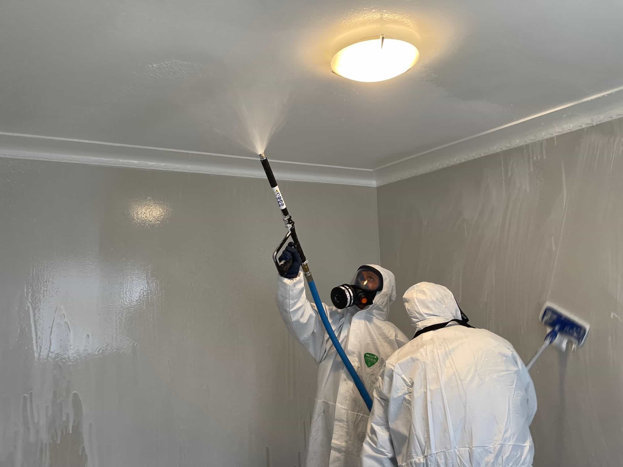 iDry technicians in full PPE spraying ceiling during meth decontamination in Auckland property